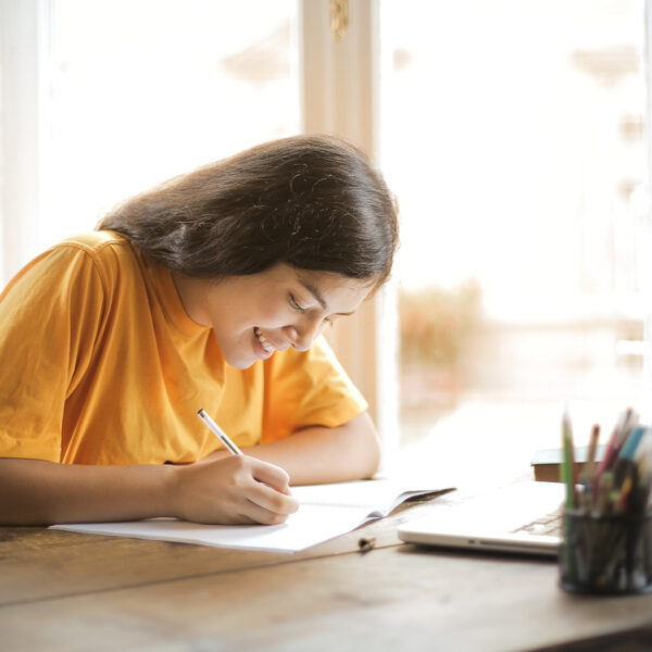 Adolescente qui écrit devant son ordinateur